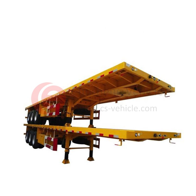 Commercial semi truck pulling a specialized flatbed trailer on a highway